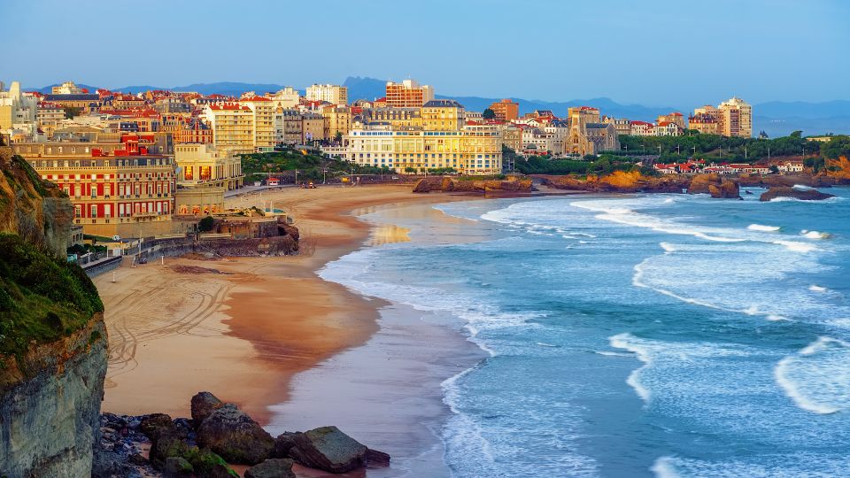 Vue sur la côte de Biarritz avec des bâtiments en bord de mer et des vagues.