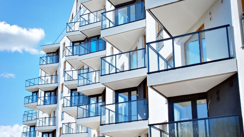 Immeuble résidentiel moderne avec des balcons vitrés et une architecture contemporaine.