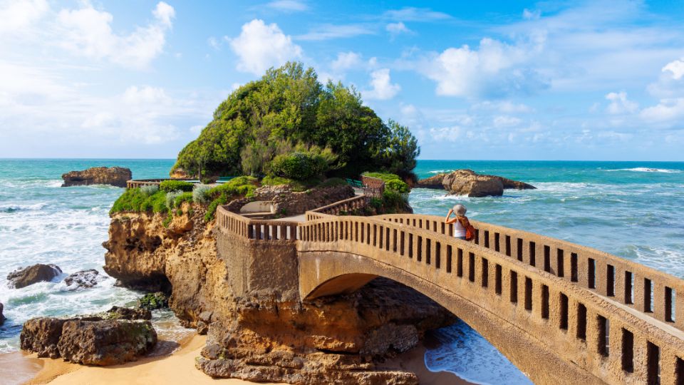 Le rocher de la Vierge à Biarritz avec un pont et l'océan en arrière-plan.